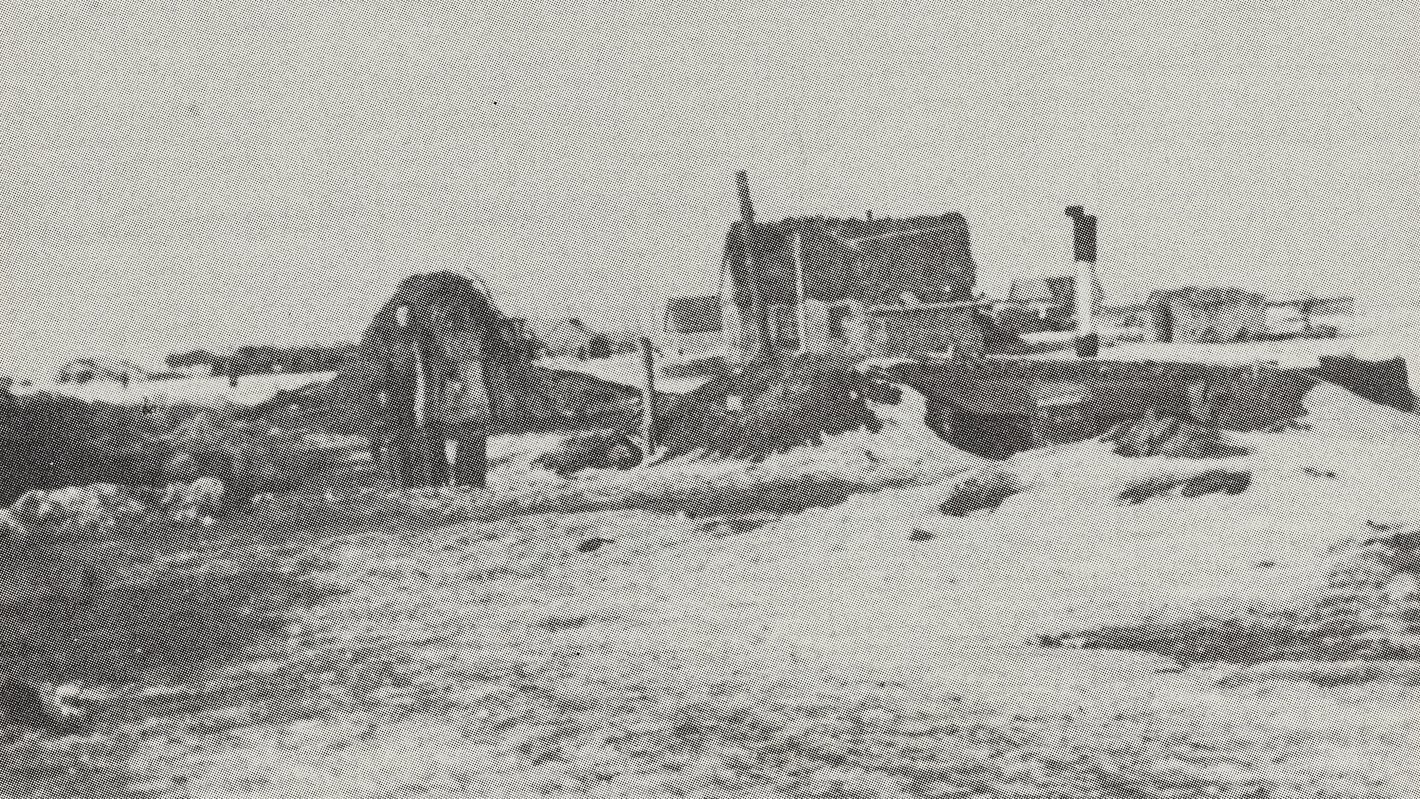 Eine Schwarz-weiß-Fotografie aus Stalingrad im Winter, auf der ein zerstörtes Haus und eine Person zu sehen sind.
